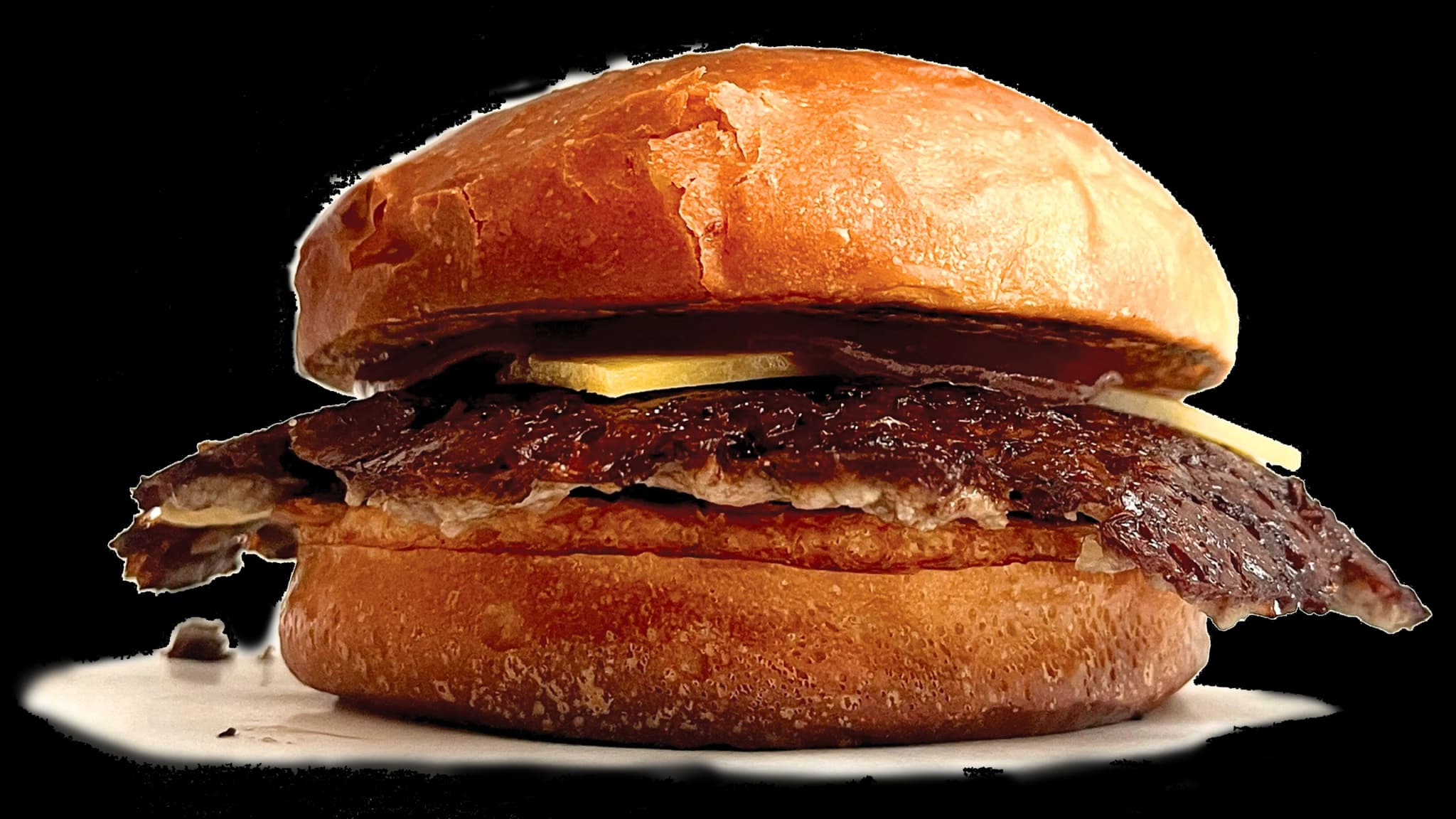 Soczysty smash burger z wołowiną Angus, świeżą sałatą, pomidorem i sosem, podany w domowej bułce - specjalność Zapini w Słupsku